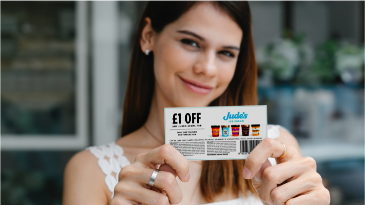 Woman holding a coupon for 10% off ice cream, which has a barcode.