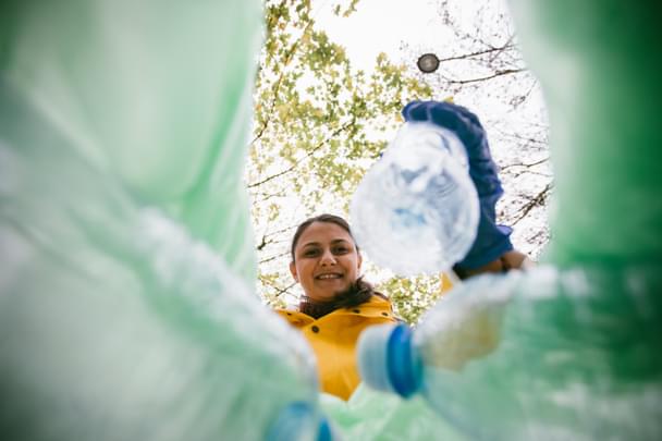 woman putting bottle in the bin 