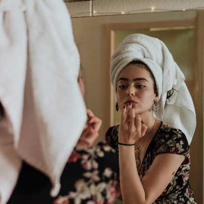 woman doing make up in mirror 
