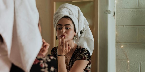 woman doing make up in mirror 