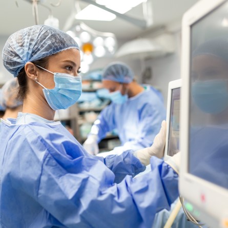 Theatre nurse using medical equipment