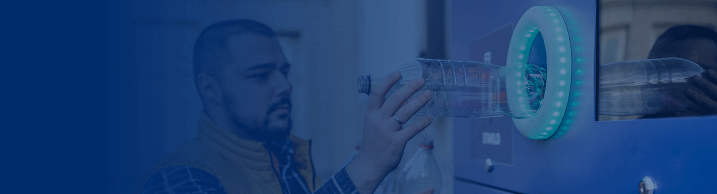 Man recycling bottle in drs machine