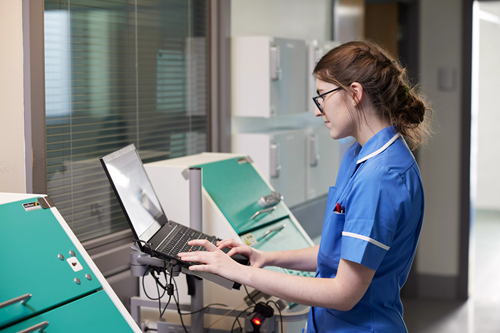 Nurse on a ward using a laptop
