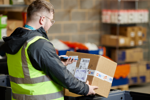 Person in a warehouse scanning a box of medical devices