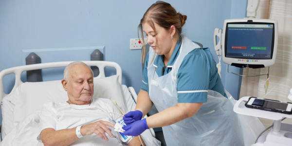 Nurse treating a patient at the patient bedside