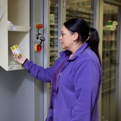 Pharmacist collecting dispensed medicine from a pharmacy robot