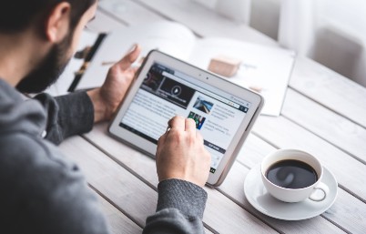 man on tablet with coffee