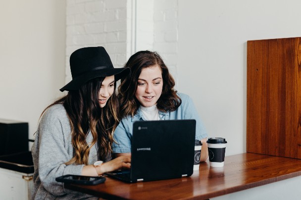 two women looking at a laptop screen